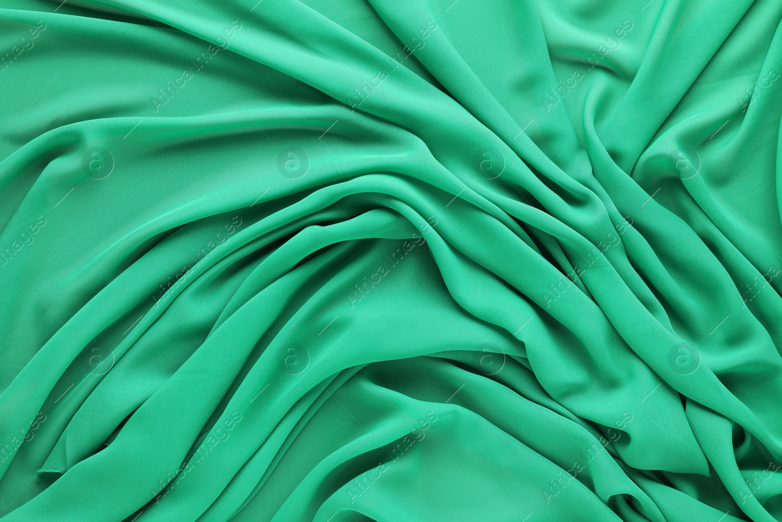 Photo of Beautiful green tulle fabric as background, top view