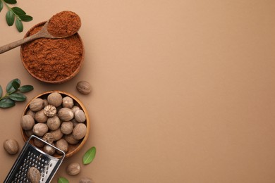 Flat lay composition with nutmegs on light brown background. Space for text