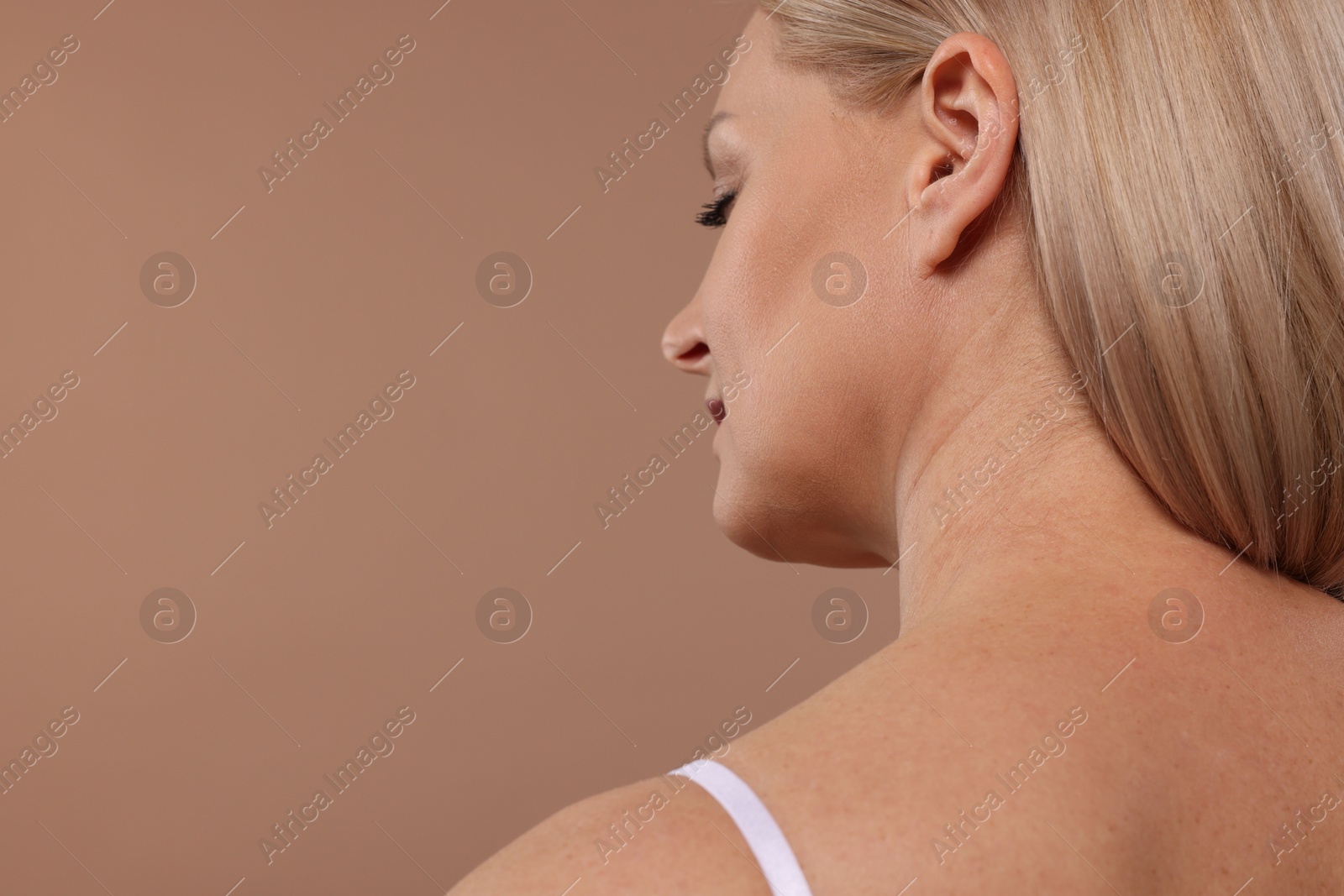 Photo of Back view of woman with healthy skin on beige background, closeup. Space for text