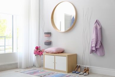 Photo of Stylish hallway interior with round mirror on white wall