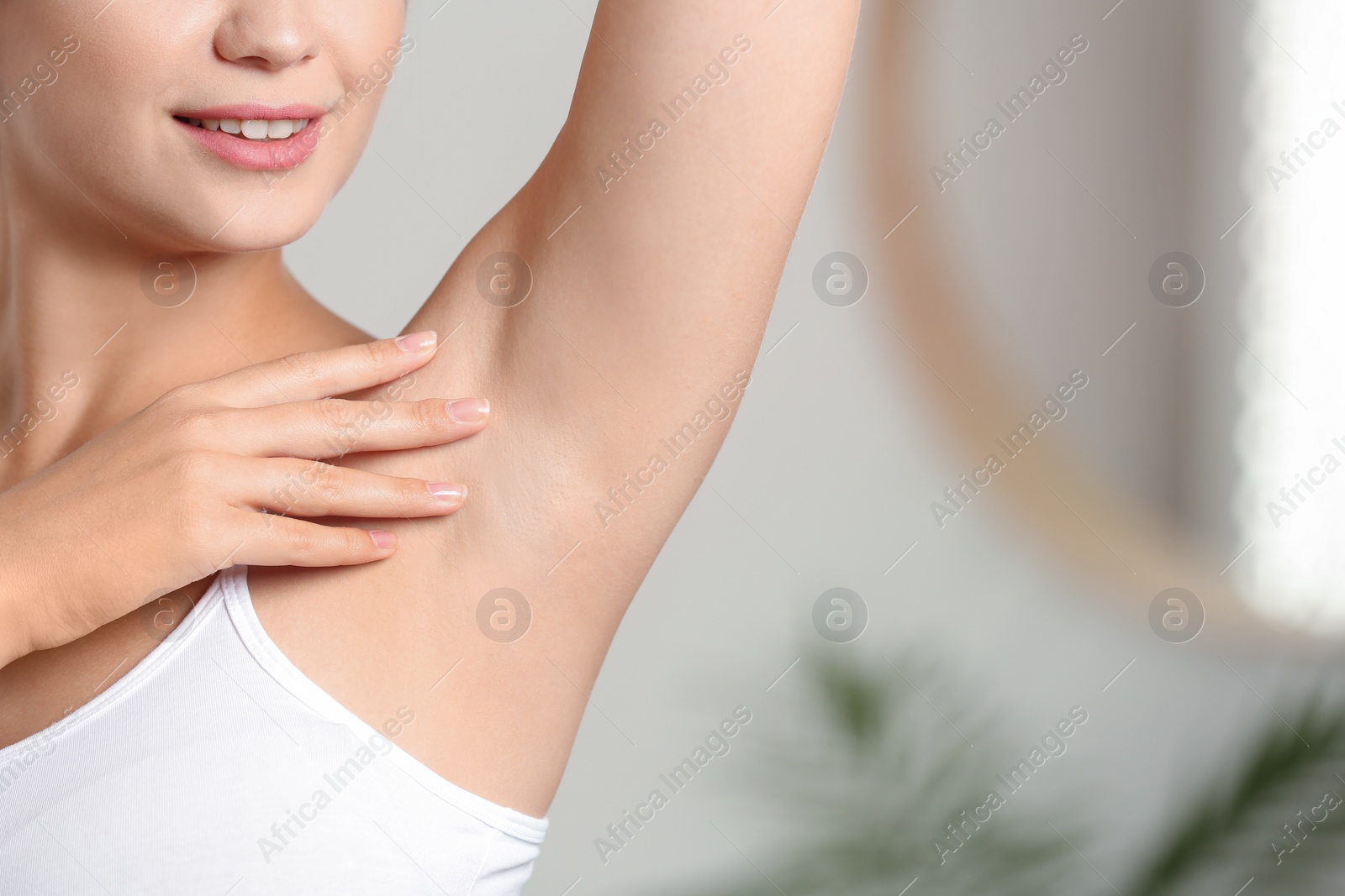 Photo of Young woman with smooth clean armpit indoors, space for text. Using deodorant