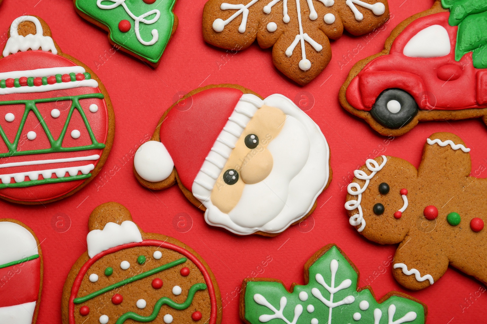 Photo of Different tasty Christmas cookies on red background, flat lay