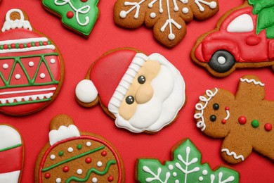 Different tasty Christmas cookies on red background, flat lay