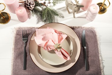 Photo of Stylish table setting with pink fabric napkin, beautiful decorative ring and festive decor on white wooden background, flat lay