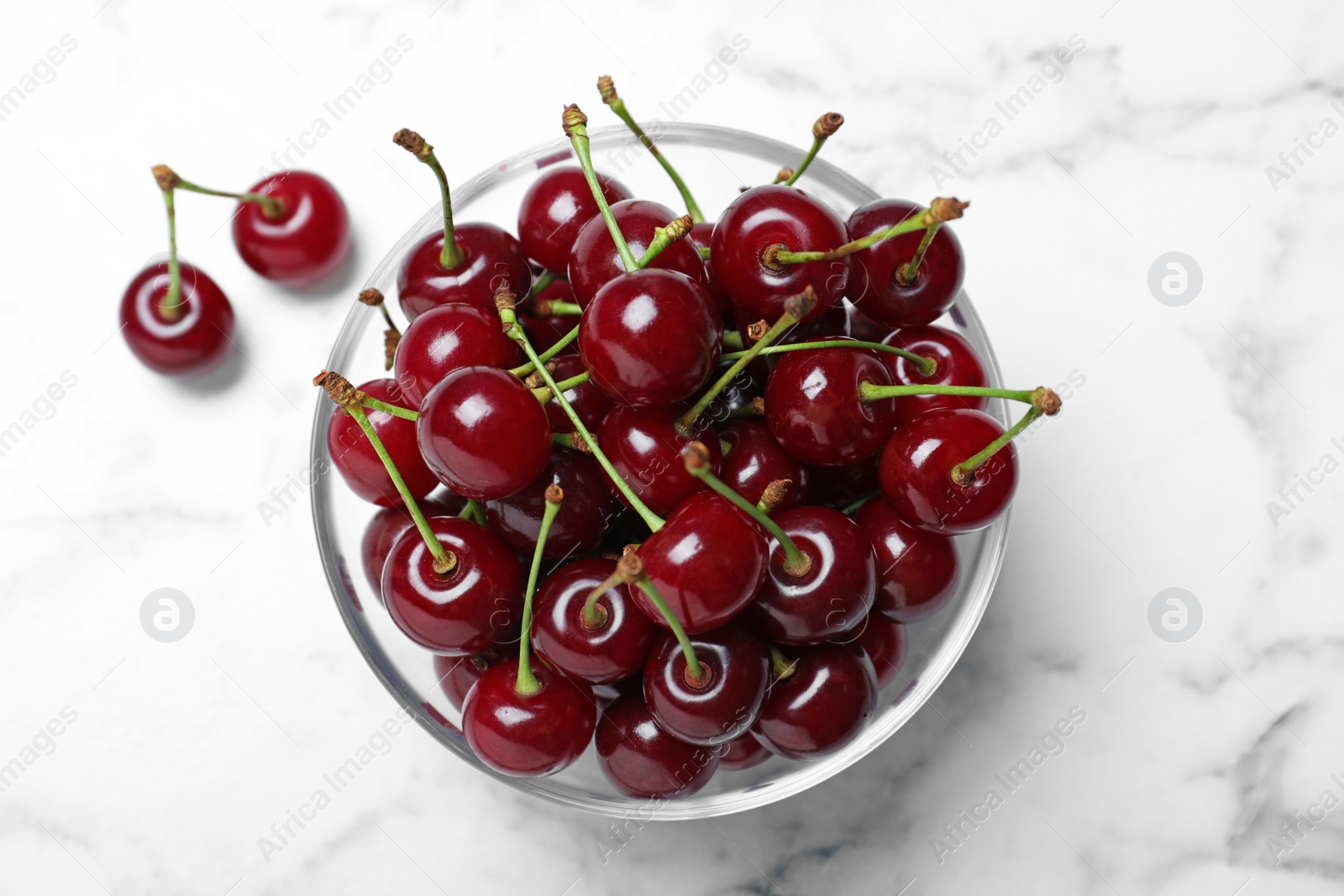 Photo of Sweet juicy cherries on white marble table, flat lay