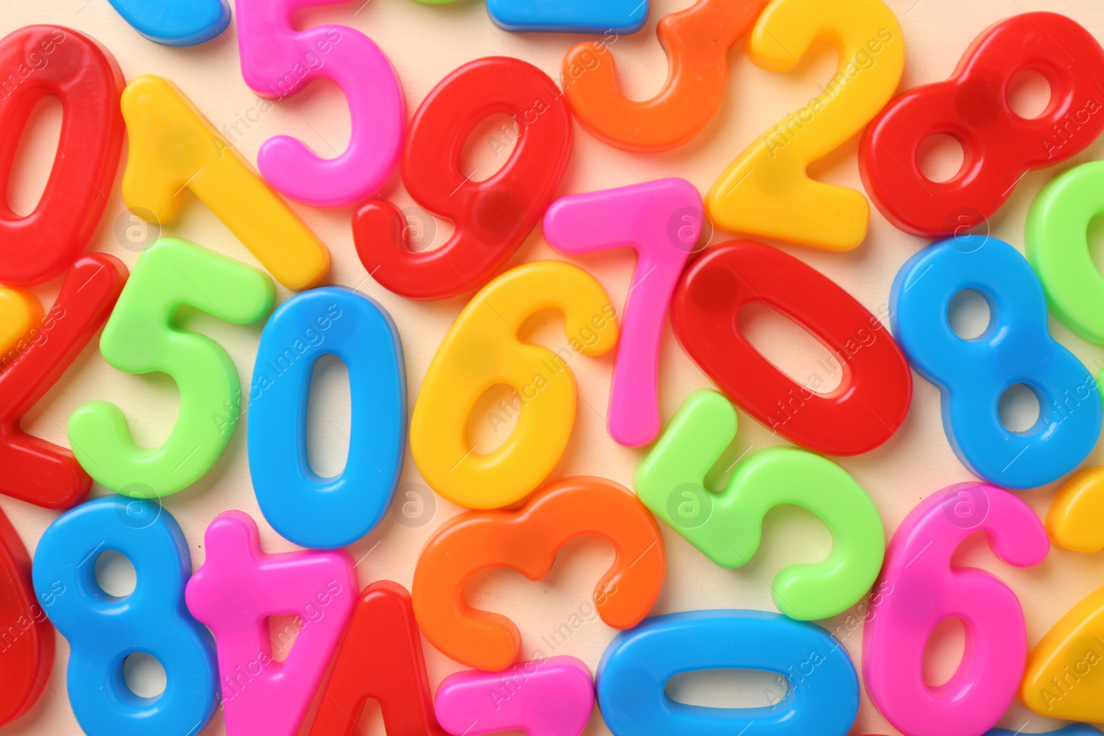 Photo of Colorful numbers on beige background, top view