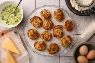 Photo of Fresh delicious puff pastry and ingredients on white tiled surface, flat lay