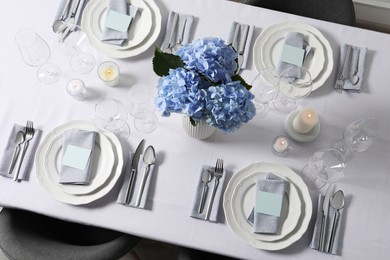 Photo of Beautiful table setting with blank cards and floral decor, top view