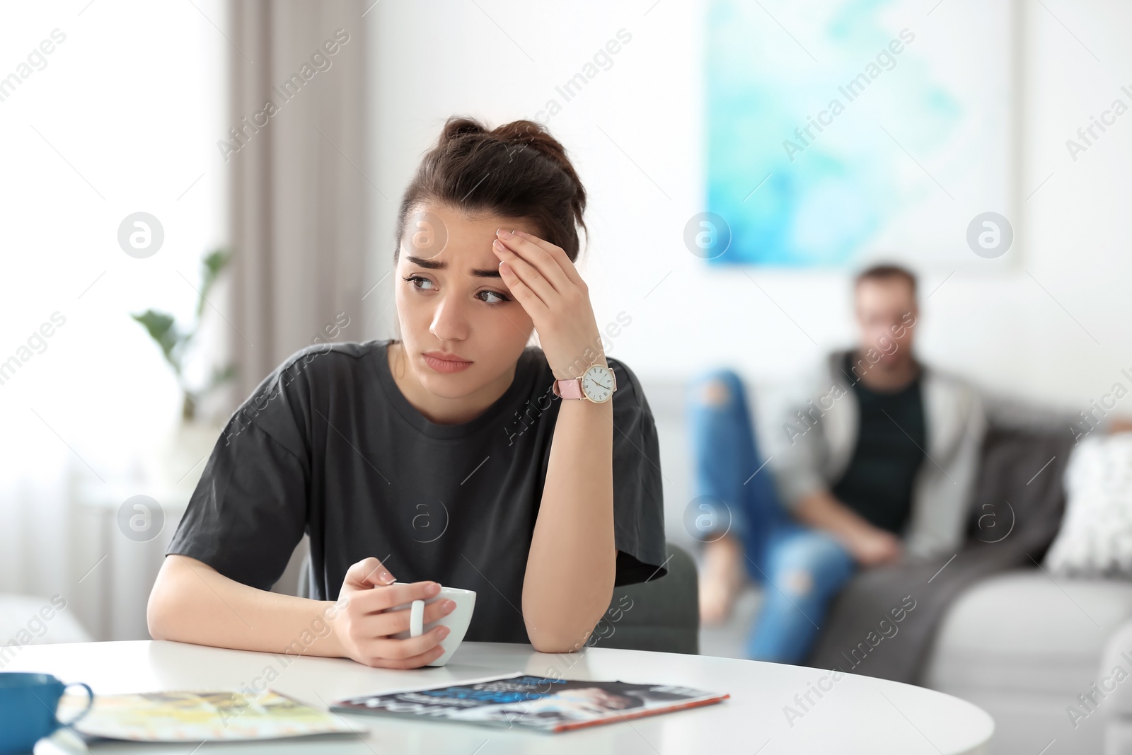 Photo of Young couple ignoring each other after having argument in living room