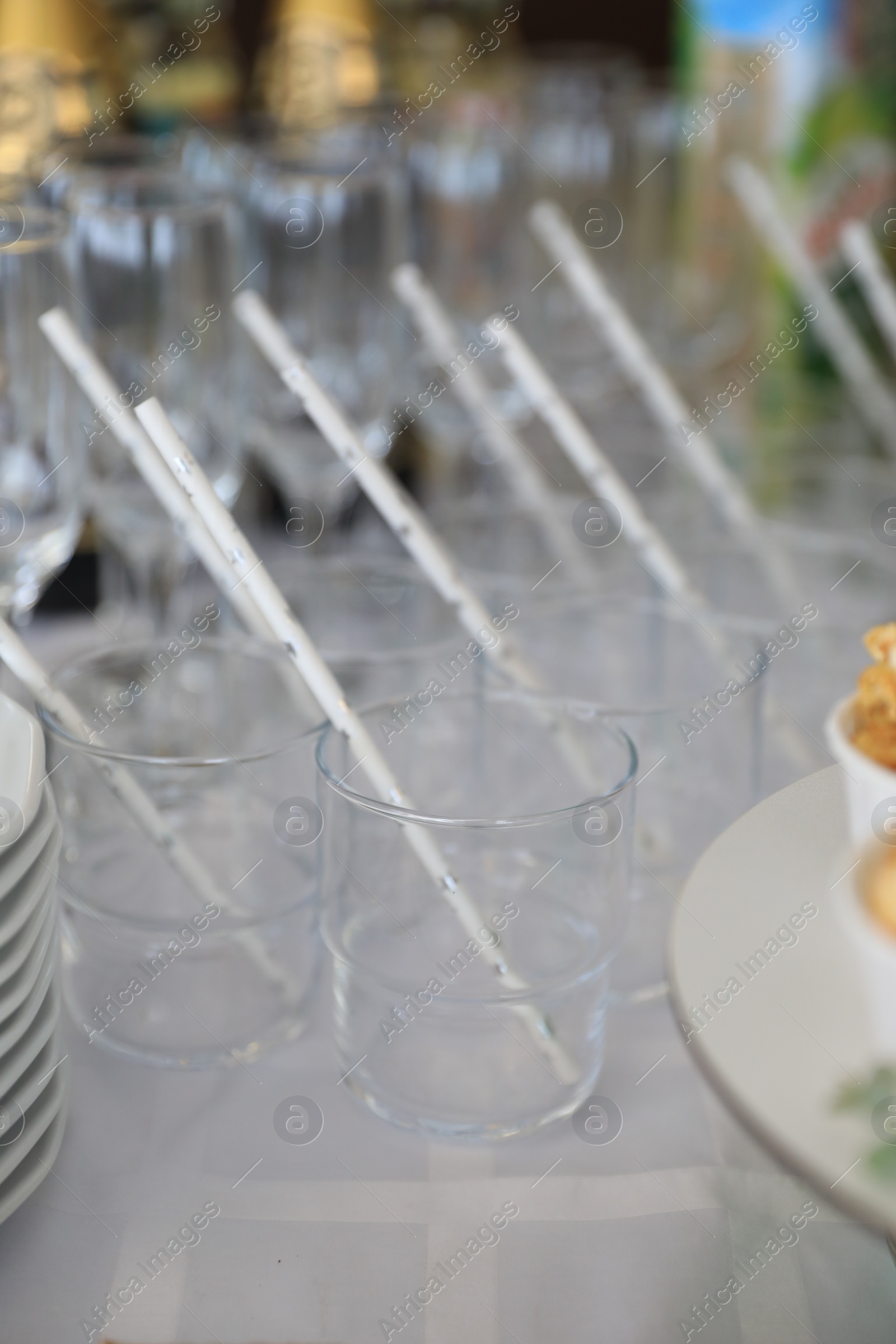 Photo of Empty glasses with paper straws on table