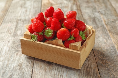 Crate with ripe strawberries on wooden background