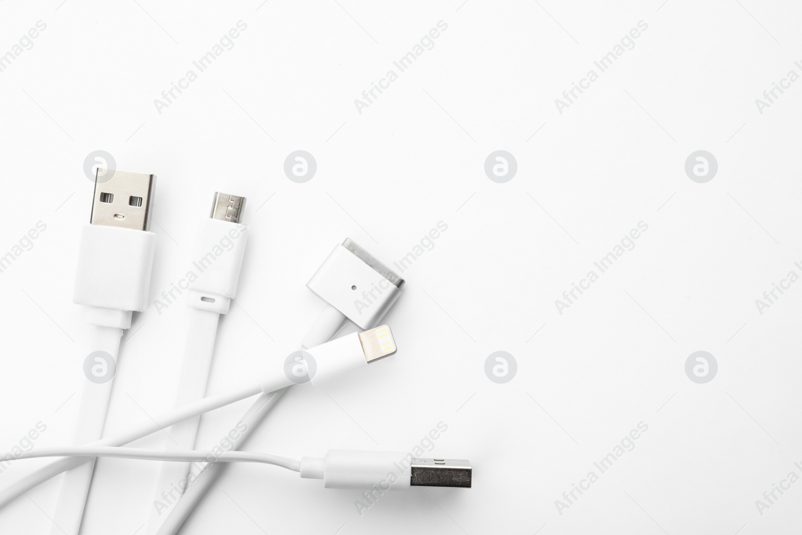 Photo of Charge cables on white background, top view. Modern technology