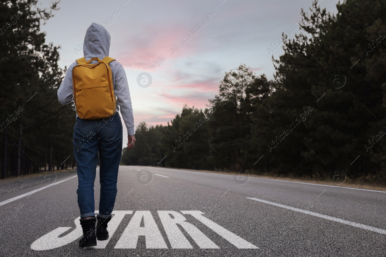 Image of Woman going along road near forest, back view