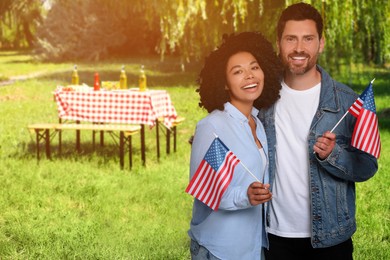 Image of 4th of July - Independence day of America. Happy couple with national flags of United States having picnic in park