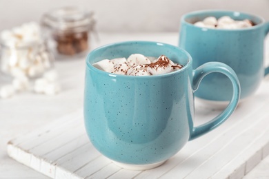 Cup of chocolate milk on light wooden background