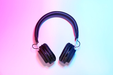 Stylish headphones on color background, top view