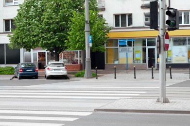 Photo of City street with zebra markings and traffic lights. Pedestrian crosswalk