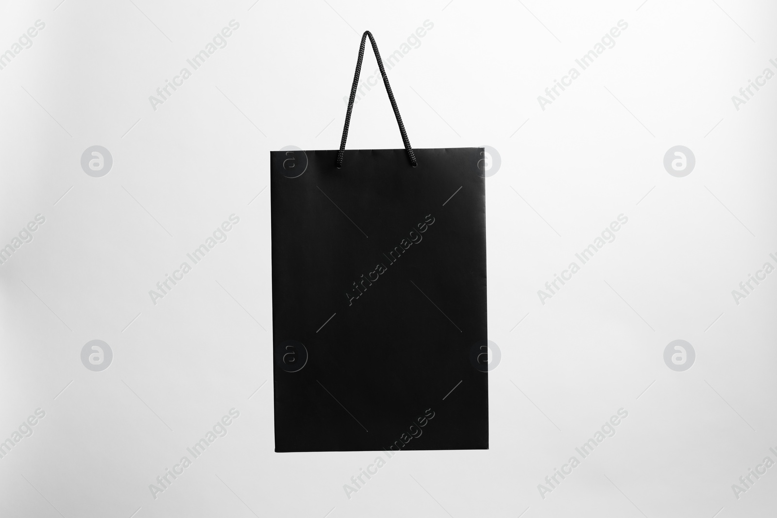 Photo of One black paper shopping bag on grey background