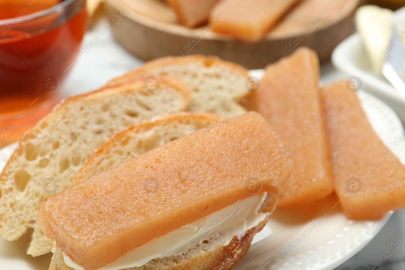 Photo of Delicious quince paste and bread on table, closeup