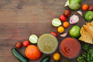 Photo of Flat lay composition of tasty salsa sauces and different ingredients on wooden table. Space for text