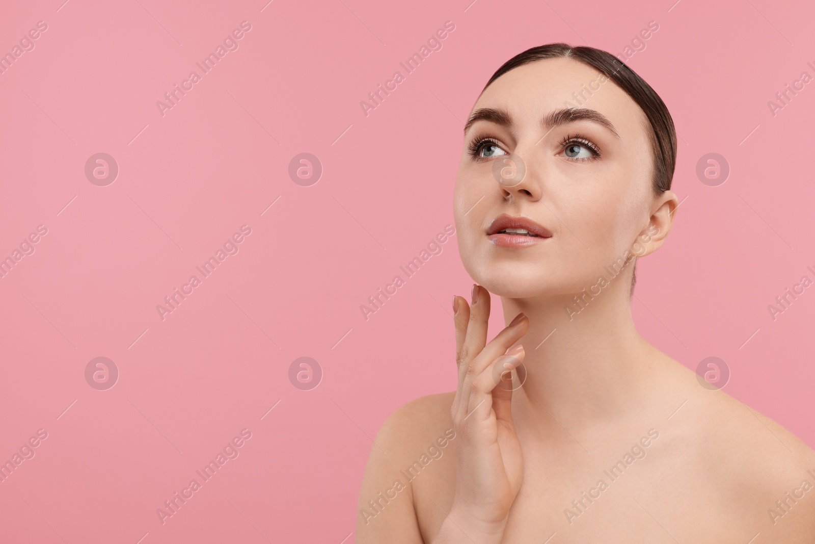 Photo of Beautiful woman touching her neck on pink background. Space for text