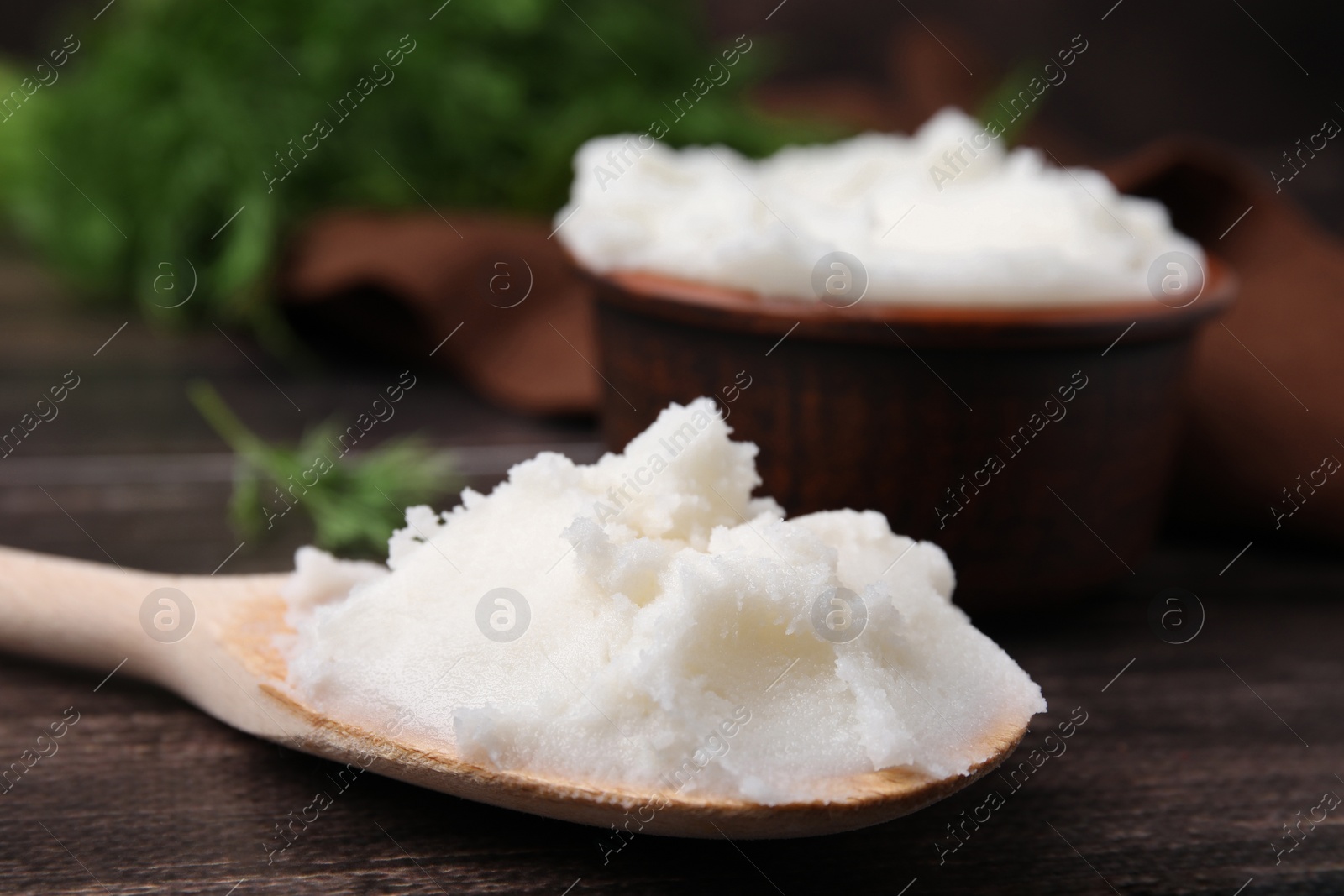 Photo of Spoon with delicious pork lard on wooden table, closeup