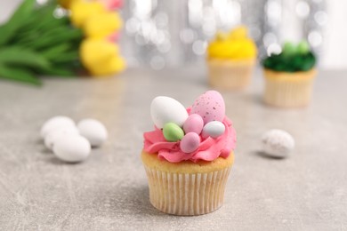 Tasty decorated Easter cupcake on grey table, closeup