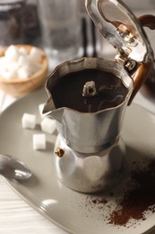 Photo of Brewed coffee in moka pot on white table, closeup