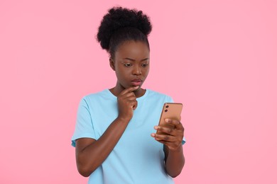 Photo of Beautiful young woman with smartphone on pink background