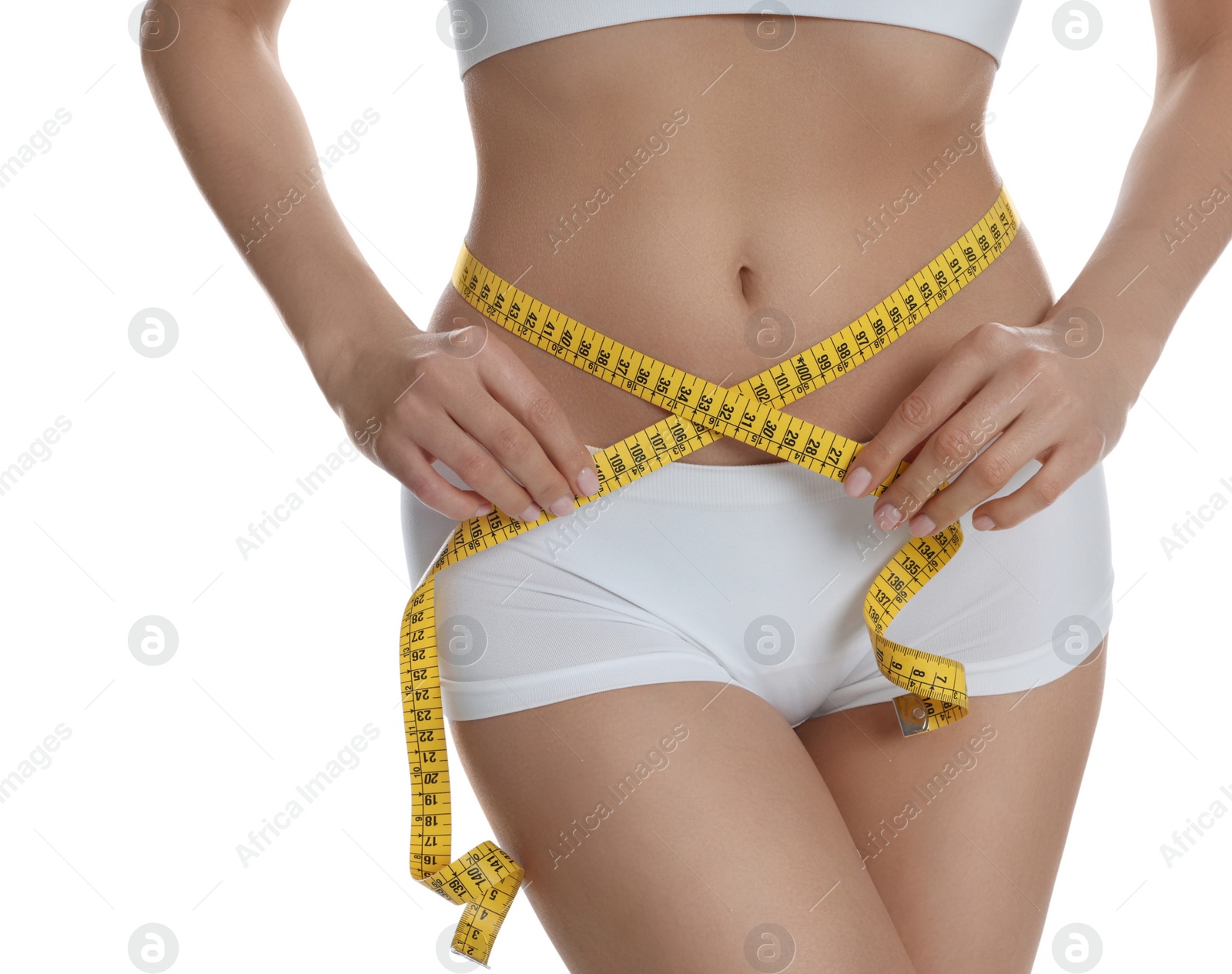 Photo of Young woman measuring waist with tape on white background, closeup