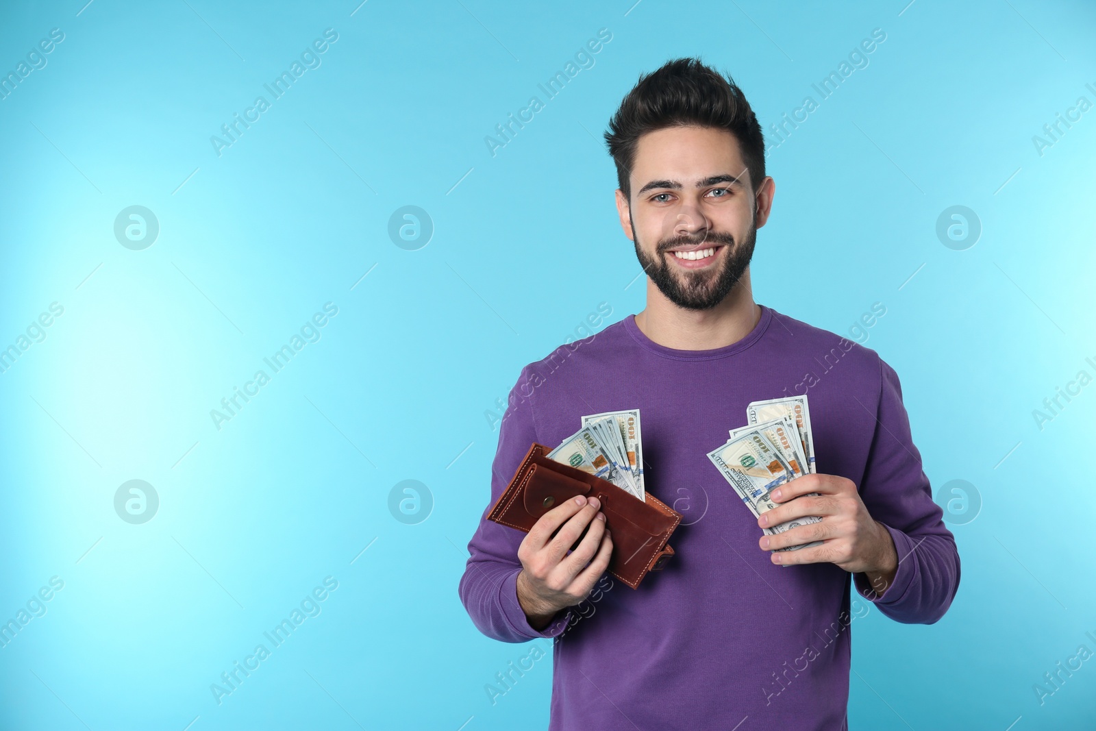 Photo of Portrait of happy young man with money on color background. Space for text