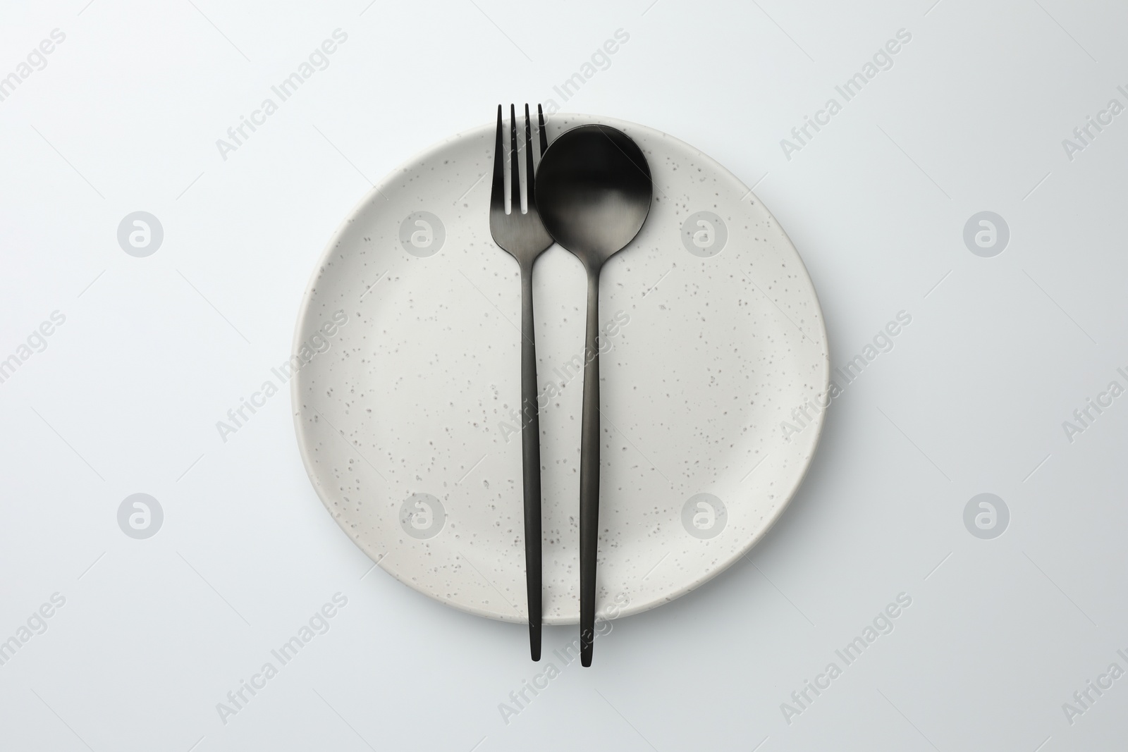 Photo of Plate, fork and spoon on white background, top view