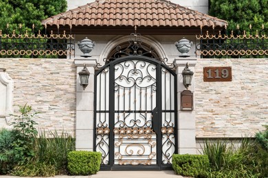 Black metal gates near beautiful house outdoors