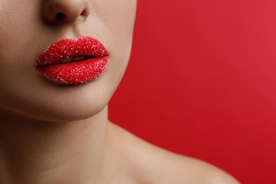 Closeup view of woman with lips covered in sugar on red background. Space for text