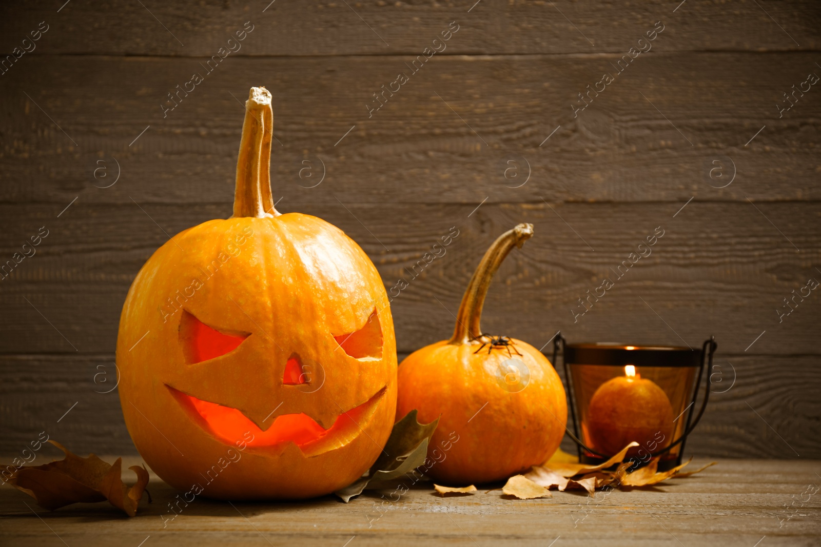 Photo of Spooky Jack pumpkin head lantern on wooden background. Halloween decoration