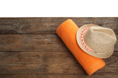 Photo of Wooden surface with beach towel and straw hat on white background, top view. Space for text