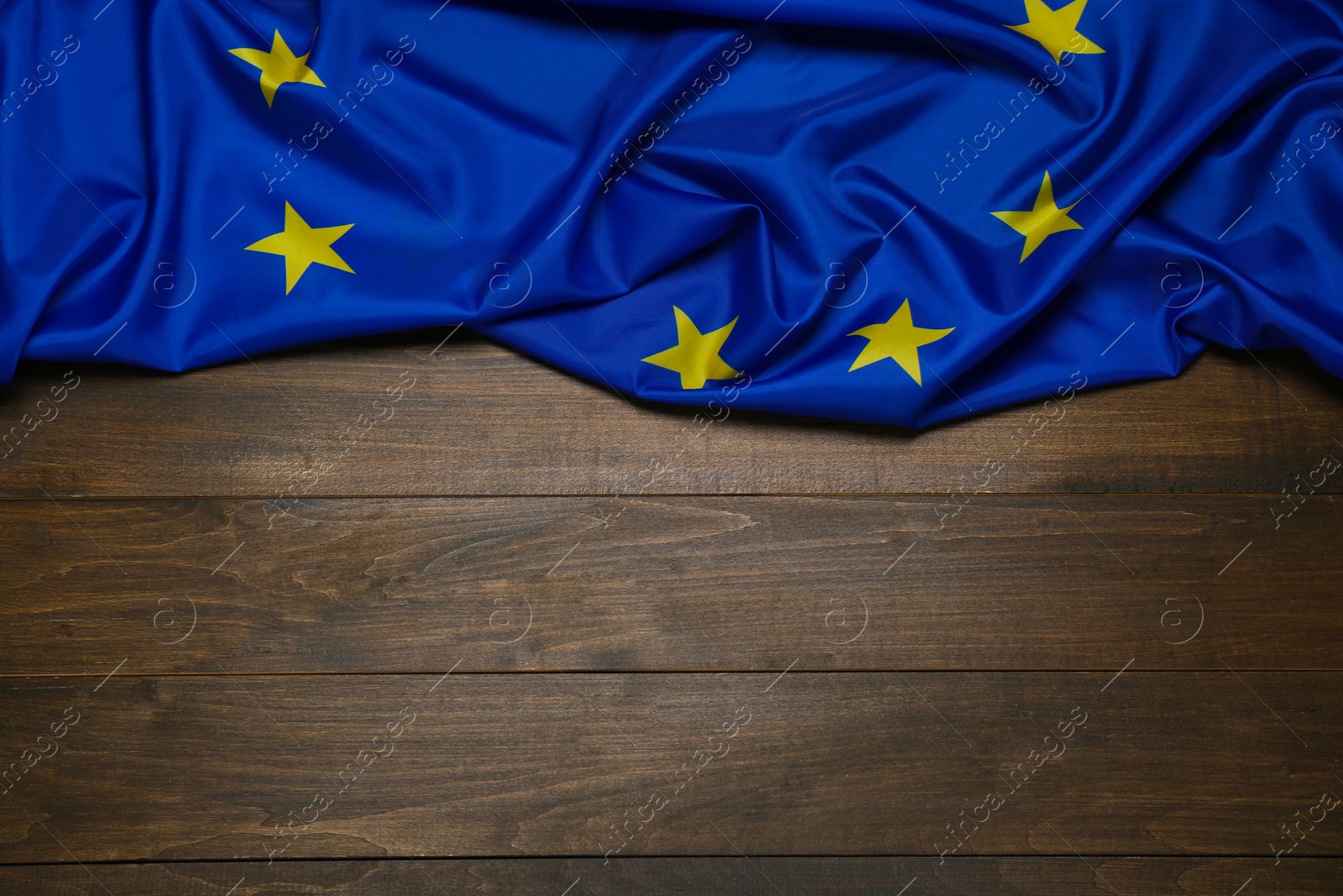 Photo of Flag of European Union on wooden background, top view. Space for text