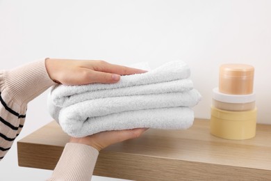Photo of Bath accessories. Woman with stack of clean towels indoors, closeup