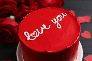 Photo of Bento cake with text Love You and roses on black table, closeup. St. Valentine's day surprise