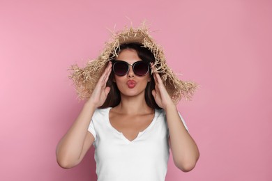 Photo of Beautiful woman with stylish straw hat and sunglasses on pink background