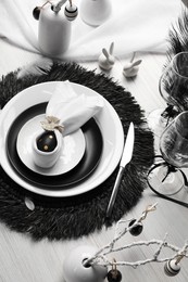Festive table setting with bunny ears made of black egg and napkin. Easter celebration