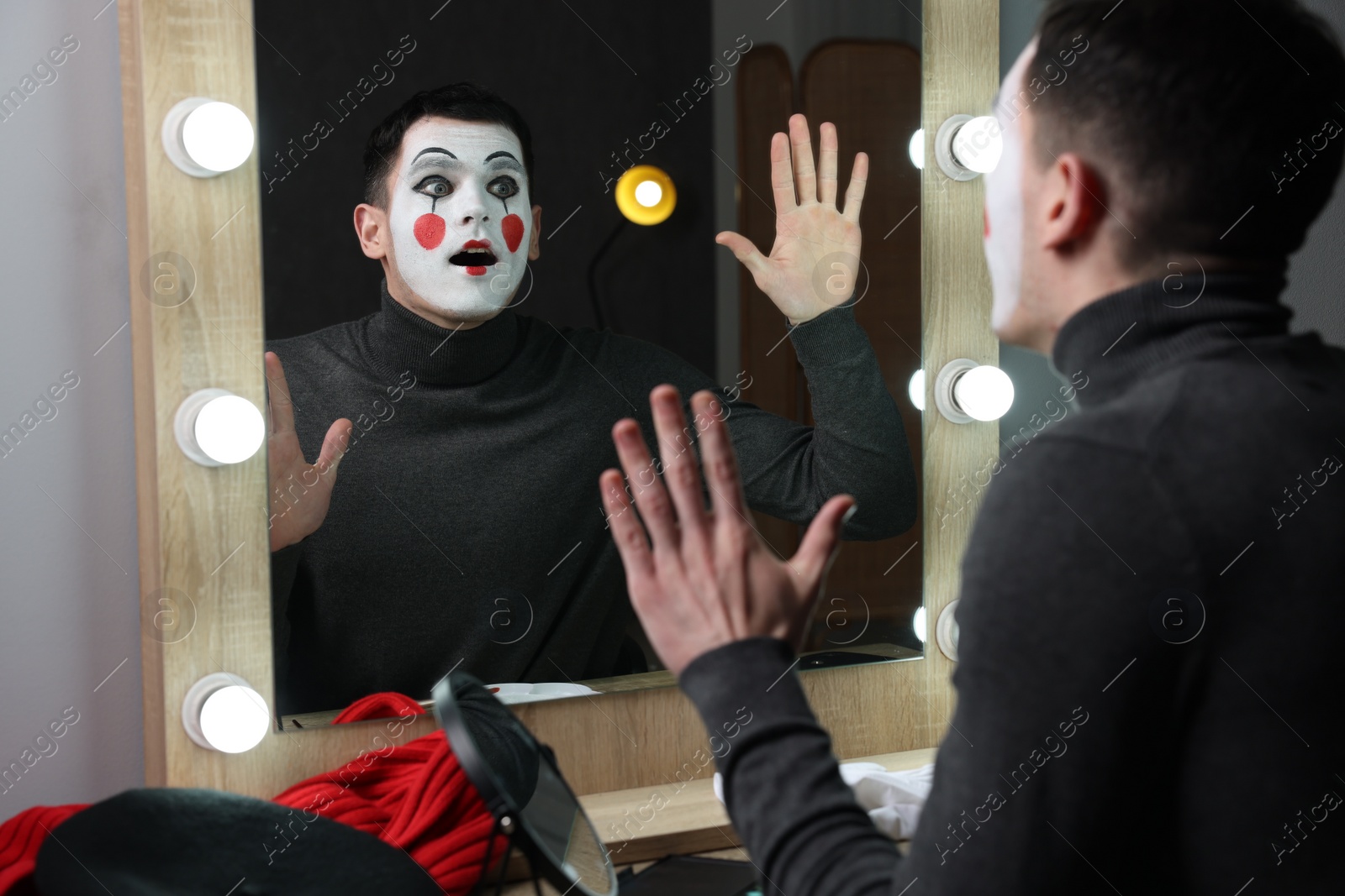 Photo of Mime artist posing near mirror in dressing room