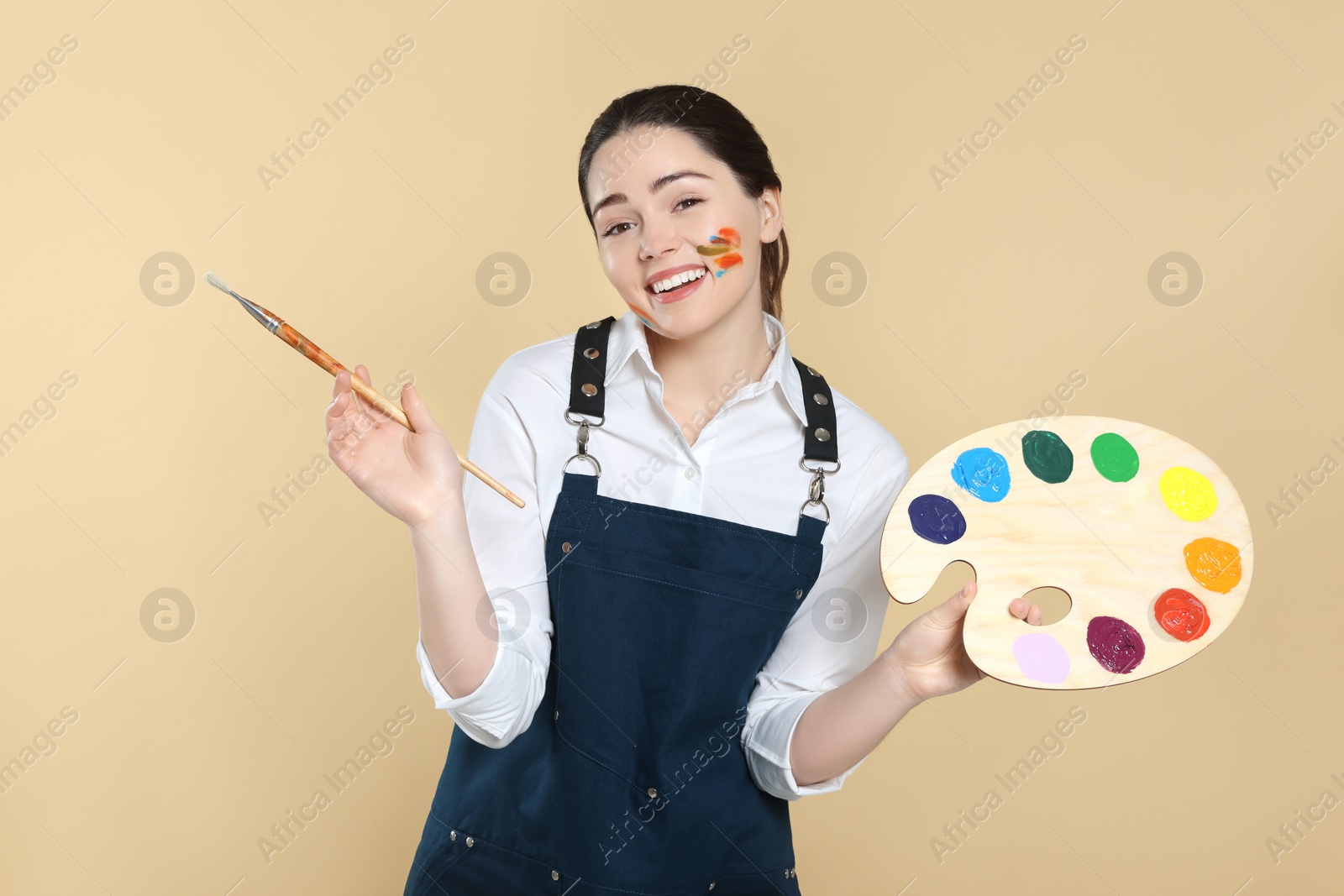 Photo of Woman with painting tools on beige background. Young artist