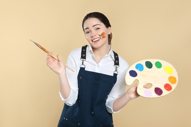 Woman with painting tools on beige background. Young artist