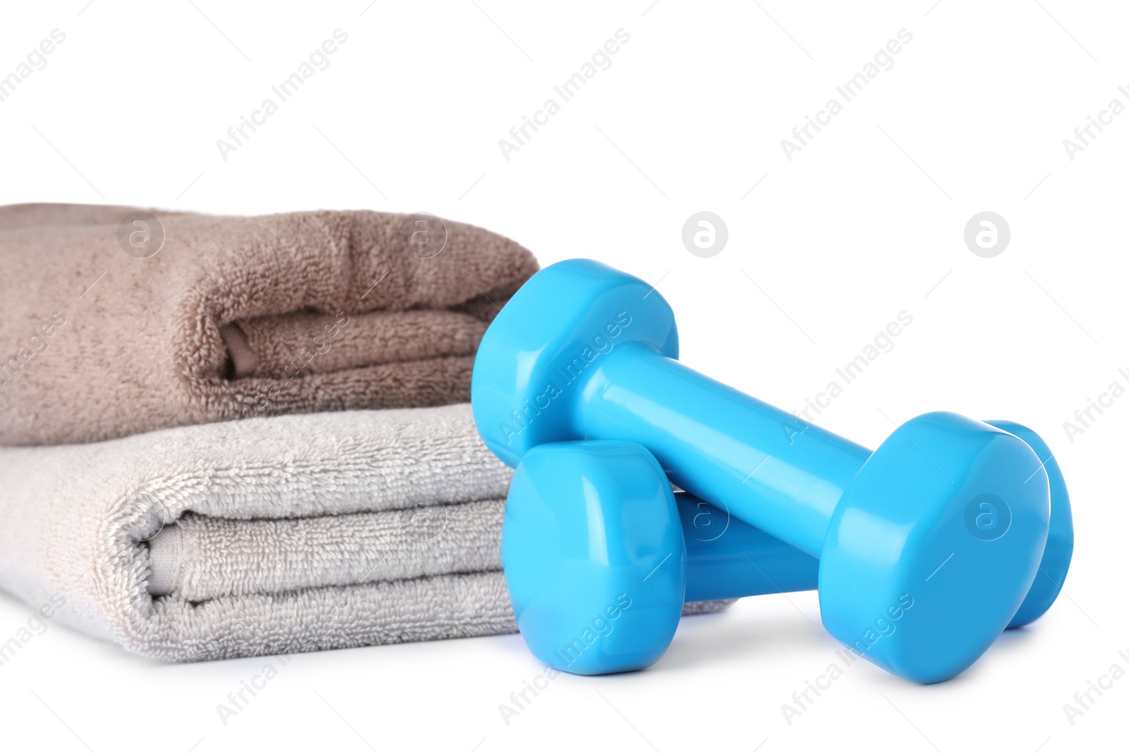 Photo of Stylish dumbbells and towels on white background. Home fitness