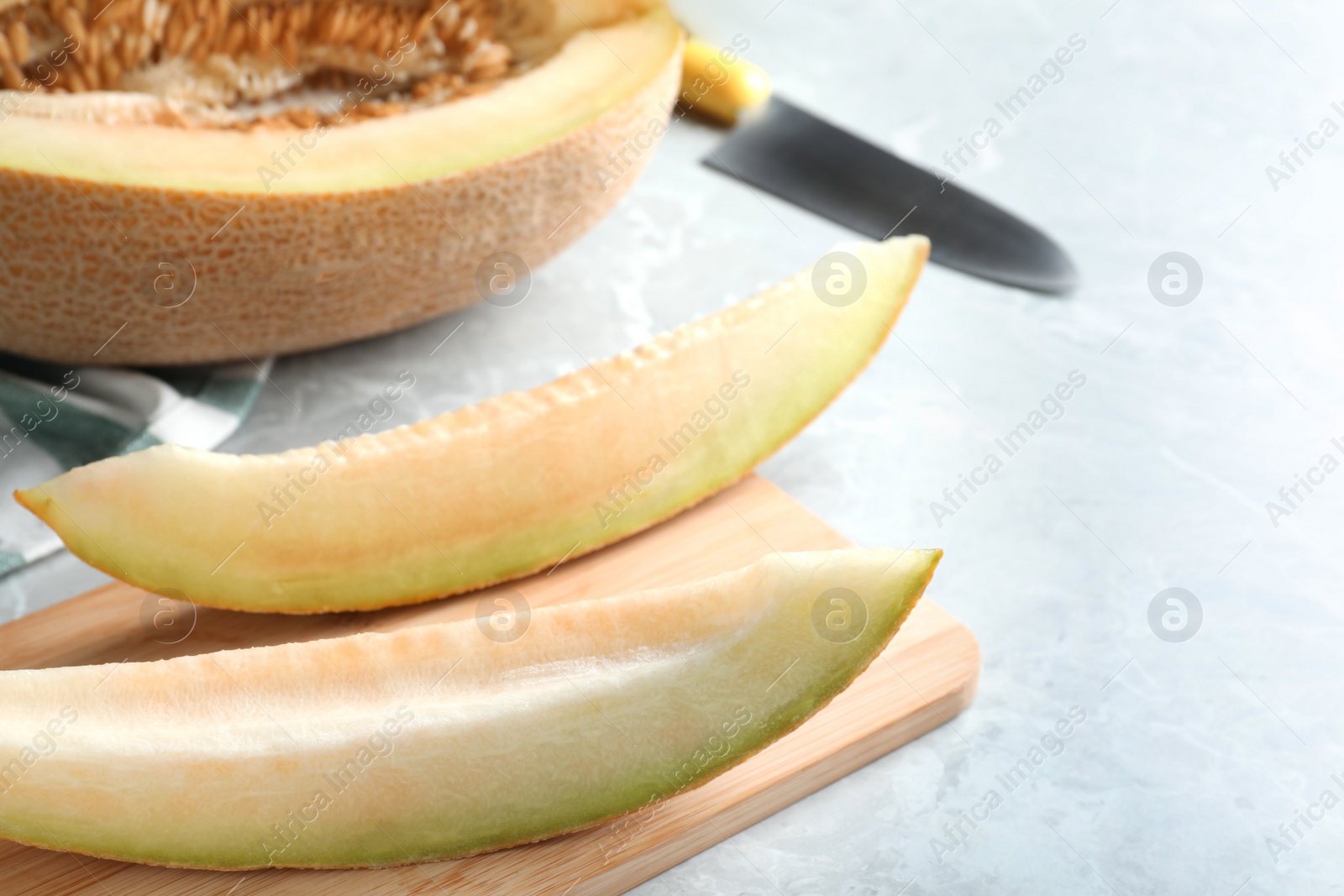 Photo of Slices of delicious ripe melon on grey marble table