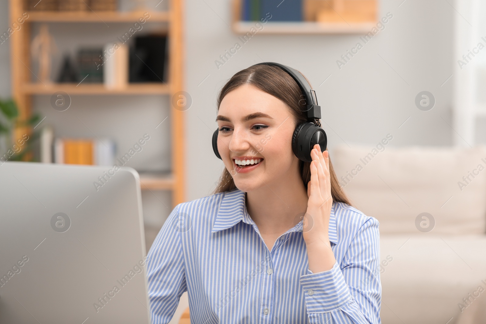 Photo of E-learning. Young woman studying with computer during online lesson indoors.