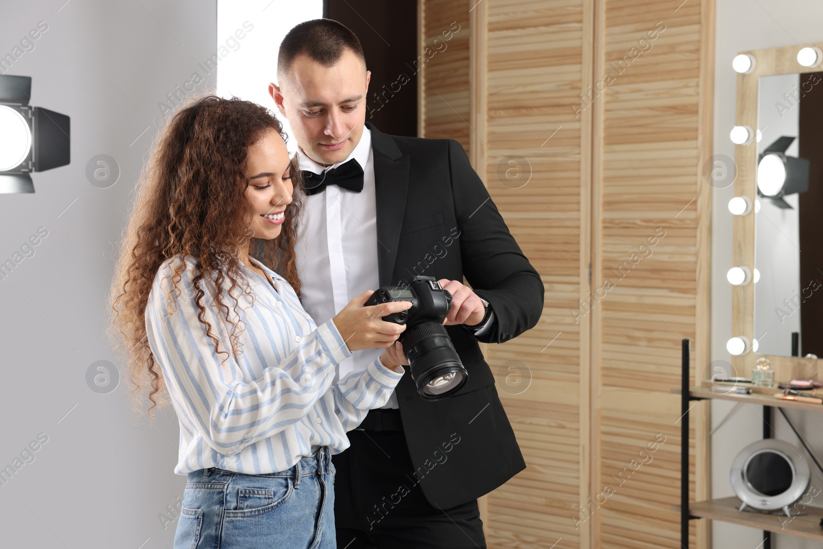 Photo of Handsome model with professional photographer in studio