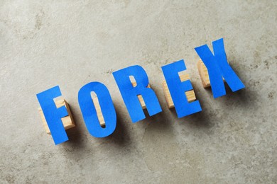 Word Forex made of blue letters and cubes on grey table, flat lay