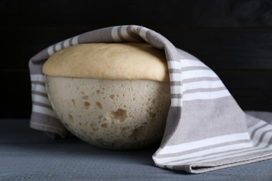 Photo of Bowl of fresh yeast dough on grey wooden table